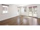 Bright living room with beautiful hardwood floors, white trim and walls, and three windows offering natural light at 2025 Ash St, Denver, CO 80207