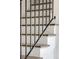 Detailed staircase featuring white risers, wood treads, and a sleek black iron railing at 2025 Ash St, Denver, CO 80207