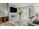 Cozy living room with a modern fireplace, plush rug, and access to the outdoor patio at 2282 Old Rail Way, Superior, CO 80027