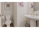 Elegant powder room featuring a modern pedestal sink, toilet, and tasteful decor at 2282 Old Rail Way, Superior, CO 80027