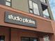 Close-up shot of 'Studio Pilates International' sign, inviting residents to a fitness-oriented urban lifestyle at 2282 Old Rail Way, Superior, CO 80027
