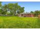 Lush backyard featuring a well-maintained lawn and mature trees providing plenty of shade and privacy at 11891 Gaylord Way, Northglenn, CO 80233