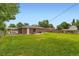 Spacious backyard with well-maintained lawn, brick patio, and a privacy fence with mature trees at 11891 Gaylord Way, Northglenn, CO 80233