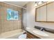 Bathroom featuring a bathtub, stylish showerhead, stained glass window, and granite countertop at 11891 Gaylord Way, Northglenn, CO 80233