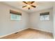 Bedroom with hardwood flooring, two windows, and a ceiling fan providing natural light at 11891 Gaylord Way, Northglenn, CO 80233
