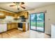 Functional kitchen with wood cabinets, laminate counters, appliances, and sliding glass door to backyard at 11891 Gaylord Way, Northglenn, CO 80233