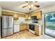 Cozy kitchen featuring stainless steel appliances, tile countertops, wood cabinets, and hardwood floors at 11891 Gaylord Way, Northglenn, CO 80233