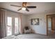 A bedroom features a ceiling fan, patio access, and a comfortable chair, blending indoor and outdoor living seamlessly at 9927 Aftonwood St, Highlands Ranch, CO 80126