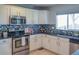 Well-appointed kitchen with stainless steel appliances, stylish tile backsplash, and bright white cabinets at 9927 Aftonwood St, Highlands Ranch, CO 80126