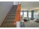 Inviting living room featuring a staircase, comfortable seating, large windows, and stylish decor at 9927 Aftonwood St, Highlands Ranch, CO 80126