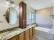 Bathroom features double sinks, granite countertops, custom cabinetry, and a large soaking tub at 1674 Bent Grass Cir, Castle Rock, CO 80109