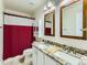 Bathroom featuring a double vanity with a granite countertop, a framed mirror, and a red and white shower curtain at 1674 Bent Grass Cir, Castle Rock, CO 80109