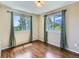 Bright bedroom featuring hardwood floors, neutral walls, and large windows with scenic outdoor views and light-filtering drapes at 1674 Bent Grass Cir, Castle Rock, CO 80109