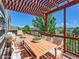 A spacious, staged, red wood deck with a pergola, offering great views of the surrounding neighborhood and landscape at 1674 Bent Grass Cir, Castle Rock, CO 80109