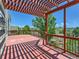 A spacious, red wood deck with a pergola, offering great views of the surrounding neighborhood and landscape at 1674 Bent Grass Cir, Castle Rock, CO 80109