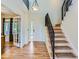 Bright foyer features hardwood floors, staircase with black iron railing, and view to living spaces at 1674 Bent Grass Cir, Castle Rock, CO 80109