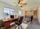 This virtually staged loft features a desk, comfortable chair, and lots of natural light at 1674 Bent Grass Cir, Castle Rock, CO 80109