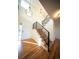 Sunlit staircase features hardwood treads, neutral carpet runner, and modern black iron railing at 1674 Bent Grass Cir, Castle Rock, CO 80109