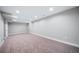 Large finished basement with neutral carpet and white walls at 3000 S Jackson St, Denver, CO 80210