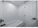 This bathroom features white textured wall tiles, a shower-tub combo, and matte black fixtures at 3000 S Jackson St, Denver, CO 80210