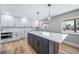 Modern kitchen with a spacious island, white cabinetry, stainless appliances, and stylish pendant lighting at 3000 S Jackson St, Denver, CO 80210
