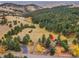 Aerial view of the residence, grounds, and surrounding mature trees at 21849 Cabrini Blvd, Golden, CO 80401