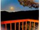 Enjoy city views from this wooden deck during a magical night with a full moon at 21849 Cabrini Blvd, Golden, CO 80401