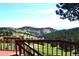 Enjoy the view from this spacious wooden deck surrounded by lush greenery and rolling hills at 21849 Cabrini Blvd, Golden, CO 80401