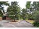 Wide circular driveway leading to a stone house, surrounded by lush landscaping and mature trees at 21849 Cabrini Blvd, Golden, CO 80401