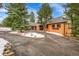 Charming single-story brick home with well-maintained landscaping, mature trees, and circular driveway at 21849 Cabrini Blvd, Golden, CO 80401