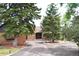 Traditional home with mature trees, rock facade, landscape, and inviting driveway at 21849 Cabrini Blvd, Golden, CO 80401