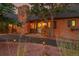 Charming home exterior with brick facade, a stone chimney, and manicured landscaping at 21849 Cabrini Blvd, Golden, CO 80401