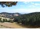 Beautiful natural landscape with rolling hills, green trees, and clear blue sky at 21849 Cabrini Blvd, Golden, CO 80401