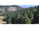 Lush mountain landscape with mature trees and a distant city view at 21849 Cabrini Blvd, Golden, CO 80401