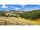Picturesque landscape view featuring rolling hills, lush trees, and a long fence line at 21849 Cabrini Blvd, Golden, CO 80401