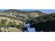A mountainous landscape with scattered snow and lush green trees under a clear sky at 21849 Cabrini Blvd, Golden, CO 80401