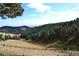 Picturesque view of rolling hills with trees, offering a serene and natural landscape scene at 21849 Cabrini Blvd, Golden, CO 80401