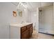Tiled bathroom featuring a shower, toilet, vanity, and mirrored cabinet at 9350 Raleigh Ct, Westminster, CO 80031