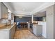 Modern kitchen and dining area featuring stainless steel appliances, tile floors, and stylish gray cabinetry at 9350 Raleigh Ct, Westminster, CO 80031