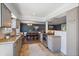 Modern kitchen and dining area featuring stainless appliances, tile floors, granite countertops, and gray cabinetry at 9350 Raleigh Ct, Westminster, CO 80031