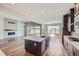 Open kitchen with a center island, stainless steel appliances, and hardwood floors, with a connecting fireplace at 574 Agoseris Way, Castle Rock, CO 80104