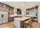 Modern kitchen boasts stainless steel appliances, dark cabinets, and a large center island with barstool seating at 574 Agoseris Way, Castle Rock, CO 80104