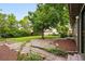 Private backyard featuring a stone patio, mature trees, and lush landscaping at 5436 E Atlantic Pl, Denver, CO 80222