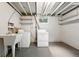 Unfinished basement area with utility sink and washer/dryer hookups near a window at 5436 E Atlantic Pl, Denver, CO 80222