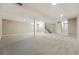 Large finished basement area featuring neutral carpet, overhead lighting, and access to stairs at 5436 E Atlantic Pl, Denver, CO 80222