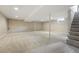 Spacious finished basement with neutral carpet, overhead lighting, and support beams at 5436 E Atlantic Pl, Denver, CO 80222