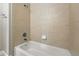 Neutral bathroom with ceramic tile walls, standard shower fixtures, and bright white bathtub at 5436 E Atlantic Pl, Denver, CO 80222