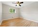 Empty bedroom featuring hardwood floors, neutral paint and a bright window at 5436 E Atlantic Pl, Denver, CO 80222
