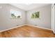 Sunlit bedroom with hardwood floors, two windows and neutral color scheme at 5436 E Atlantic Pl, Denver, CO 80222