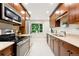 Galley kitchen with granite countertops, stainless steel appliances, and wood cabinets at 5436 E Atlantic Pl, Denver, CO 80222